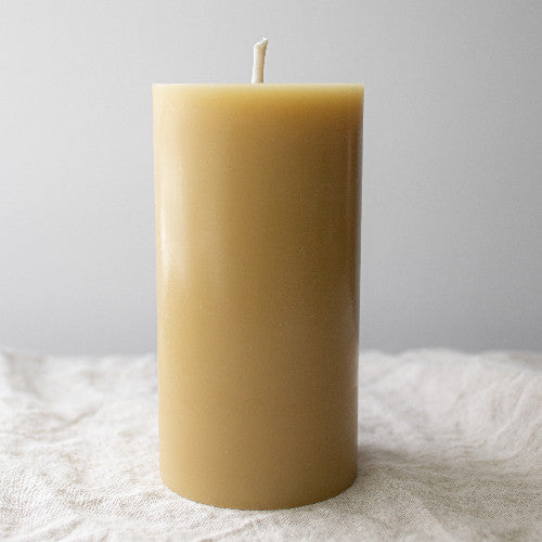 Pure beeswax pillar candle by Serenes Beeswaxory, 15cm tall, showcasing natural beeswax texture and warm candle glow.