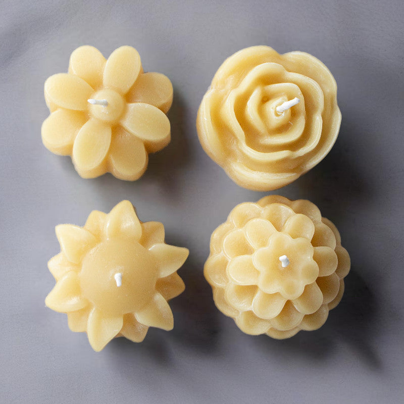 Box of four Serenes Beeswaxory flower-shaped pure beeswax tealight candles with delicate floral design.