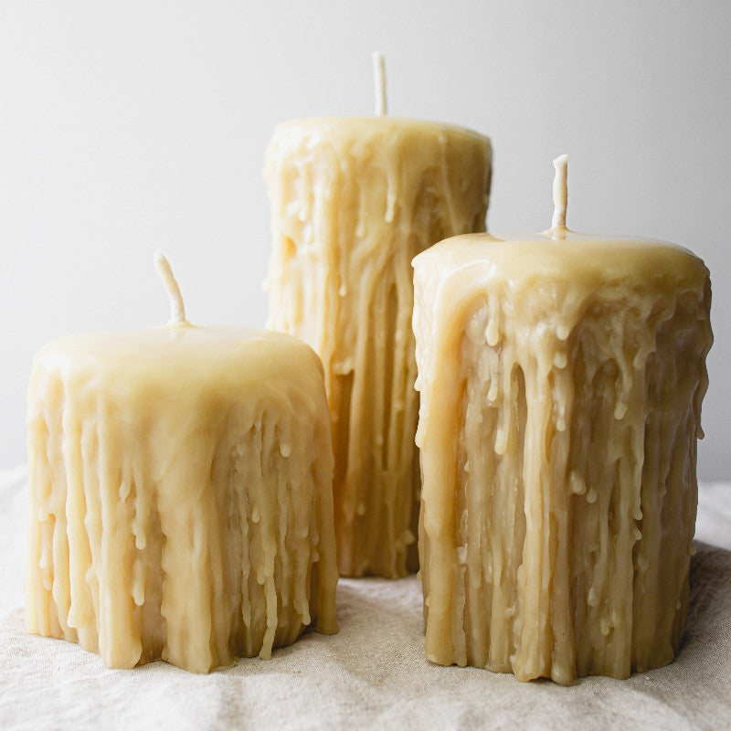 Set of three Gothic-style Serenes Beeswaxory pure beeswax pillar candles on a dark surface with ornate details.