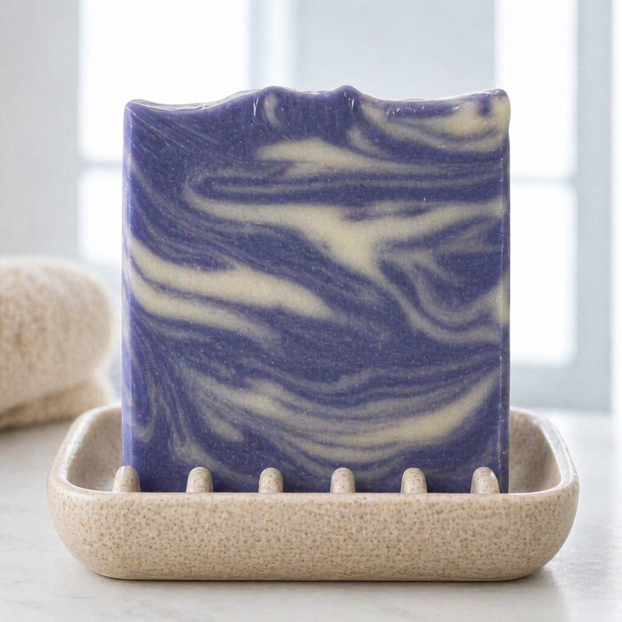 Handmade pure soap by Serenes Beeswaxory with fresh orchid and castor oil, showing a bar of soap with floral and oil elements.